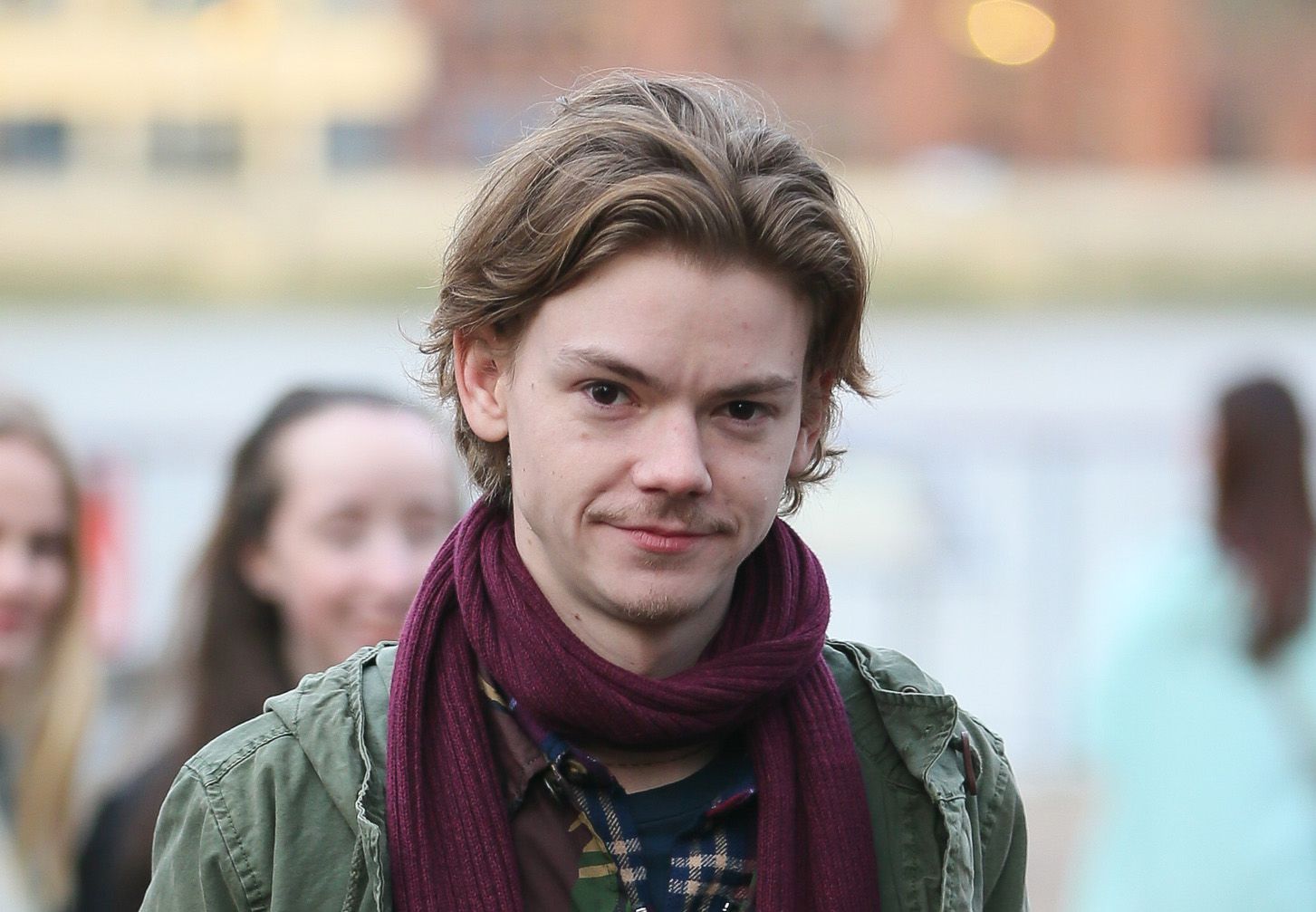 An older Thomas Brodie-Sangster smirking