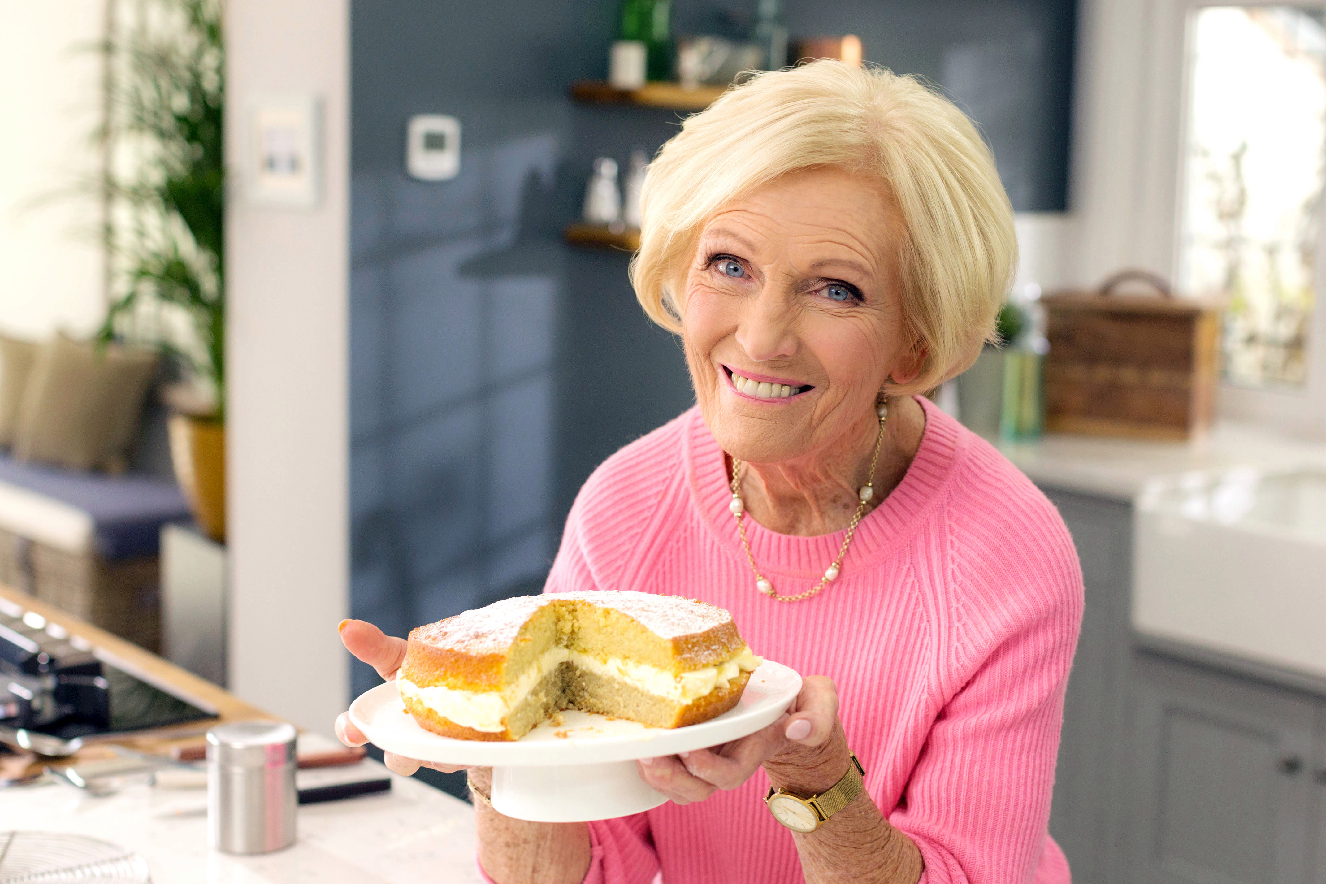 Mary Berry Net Worth posing with a cake
