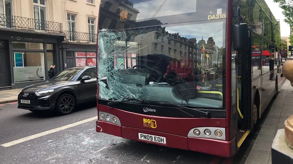 Bus window broken following military horses in London. 